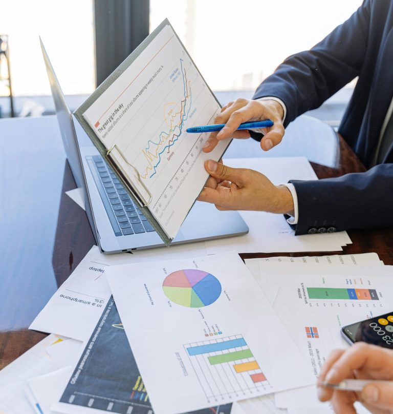 Business professionals discussing financial graphs and charts in an office setting.